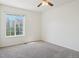 Bright bedroom with neutral carpet, large window providing community views, and a ceiling fan with light fixture at 21642 E 55Th Ave, Denver, CO 80249