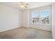 A sunlit bedroom featuring neutral carpet, white walls and trim, and a ceiling fan with light fixture at 21642 E 55Th Ave, Denver, CO 80249