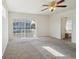 Bedroom with neutral carpet, ceiling fan, and sliding glass doors to a balcony, leading to an attached bathroom at 21642 E 55Th Ave, Denver, CO 80249