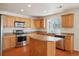 Charming kitchen is equipped with stainless steel appliances, island, and wood cabinets at 21642 E 55Th Ave, Denver, CO 80249