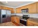 Well-equipped kitchen with wood cabinets, stainless steel appliances and laminate countertop at 21642 E 55Th Ave, Denver, CO 80249