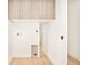 Laundry room with light wood cabinets and flooring at 3433 Lawrence St # 1, Denver, CO 80205