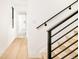 Modern stairwell with metal railing and light wood flooring at 3433 Lawrence St # 1, Denver, CO 80205