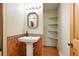 Charming bathroom featuring a pedestal sink, decorative tile accents, and convenient open shelving at 7221 S Brook Forest Rd, Evergreen, CO 80439