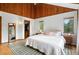 Bright bedroom offers vaulted ceiling, wood paneled accent wall, and ensuite walk-in closet at 7221 S Brook Forest Rd, Evergreen, CO 80439