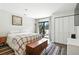 Bright bedroom with stylish plaid blanket, wood flooring, and a view of a patio at 7221 S Brook Forest Rd, Evergreen, CO 80439