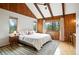 Bedroom with wood paneled walls, vaulted ceiling, and windows with natural light at 7221 S Brook Forest Rd, Evergreen, CO 80439