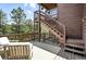 Outdoor deck featuring wooden stairs, comfortable seating, and scenic views of the surrounding landscape at 7221 S Brook Forest Rd, Evergreen, CO 80439