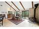 Dining room with a fireplace, wood beams, and access to outdoor deck space at 7221 S Brook Forest Rd, Evergreen, CO 80439