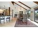 Open dining area connecting the kitchen and living spaces, featuring hardwood floors and a view of the outdoors at 7221 S Brook Forest Rd, Evergreen, CO 80439