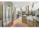 Bright kitchen with stainless steel appliances, wooden floors and open to dining area at 7221 S Brook Forest Rd, Evergreen, CO 80439