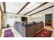 Bright living room with exposed wood beams, large sectional sofa, and hardwood floors at 7221 S Brook Forest Rd, Evergreen, CO 80439