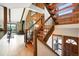 Living room with wooden staircase, wood paneling, and fireplace with stone accent wall at 7221 S Brook Forest Rd, Evergreen, CO 80439