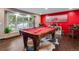 Game room with pool table, red walls, and large windows at 10399 Zenobia Ct, Westminster, CO 80031