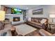 Living room with fireplace, hardwood floors, and brown leather furniture at 10399 Zenobia Ct, Westminster, CO 80031