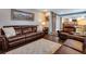 Living room with brown leather furniture, hardwood floors, and view to kitchen at 10399 Zenobia Ct, Westminster, CO 80031