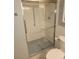 Bathroom shower with clear glass door and ceramic tile walls at 710 S Clinton St # 3A, Denver, CO 80247