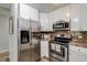 Modern kitchen with stainless steel appliances, white cabinets, and an eye-catching backsplash at 710 S Clinton St # 3A, Denver, CO 80247