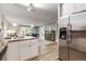 Open kitchen with stainless steel refrigerator, modern countertops, and adjacent living area at 710 S Clinton St # 3A, Denver, CO 80247