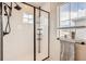 Modern bathroom features a glass enclosed shower, subway tile, and a window for natural light at 8822 Fraser River Loop, Littleton, CO 80125
