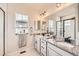 Bathroom with double vanity, granite countertop and large framed mirror with modern sconces and lighting at 8822 Fraser River Loop, Littleton, CO 80125