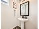 Chic powder room with pedestal sink, dark accents, and modern fixtures for a stylish and functional space at 8822 Fraser River Loop, Littleton, CO 80125