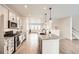 Stylish kitchen with stainless steel appliances, a large island with seating, and an open layout to the living area at 8822 Fraser River Loop, Littleton, CO 80125