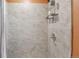 Bathroom shower stall, featuring marble tile, chrome fixtures, and a built-in shelving unit at 11390 Shimley Rd, Golden, CO 80403