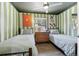 Fun bedroom with colorful striped walls, a decorative ceiling fan, and twin beds at 11390 Shimley Rd, Golden, CO 80403