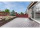 View of the back deck featuring an outdoor patio, a red fence and a view of the lovely, landscaped backyard at 2741 Poplar Grove Pl, Castle Rock, CO 80109