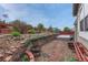 A beautiful backyard features a retaining wall, brick pavers, a small deck, and red fencing at 2741 Poplar Grove Pl, Castle Rock, CO 80109