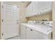Functional laundry room with washer, dryer, overhead cabinets, and exterior access at 2741 Poplar Grove Pl, Castle Rock, CO 80109