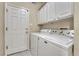 This laundry room features a washer, dryer, and ample cabinet space at 2741 Poplar Grove Pl, Castle Rock, CO 80109