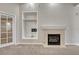 Bright living room featuring a tiled fireplace, built-in shelving, and plush carpeting at 2741 Poplar Grove Pl, Castle Rock, CO 80109