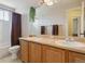 Well-lit bathroom featuring double sinks, a large mirror, and a shower with a curtain and a white tile surround at 3978 Aspen Hollow Ct, Castle Rock, CO 80104