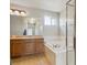 Bathroom featuring a soaking tub with glass shower and a double sink vanity at 3978 Aspen Hollow Ct, Castle Rock, CO 80104