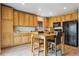 Functional kitchen featuring wooden cabinets, black appliances, and a cozy dining area at 3978 Aspen Hollow Ct, Castle Rock, CO 80104