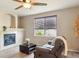 Comfortable living room featuring a cozy fireplace, ceiling fan and window with natural light at 3978 Aspen Hollow Ct, Castle Rock, CO 80104