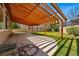 Back patio with wooden pergola overlooking the backyard and green lawn at 19061 E Powers Pl, Aurora, CO 80015