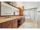 A bathroom featuring dual sinks, a soaking tub, and a glass door shower at 19061 E Powers Pl, Aurora, CO 80015