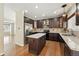 Kitchen boasts stainless steel appliances, dark wood cabinets, granite countertops, and a kitchen island at 19061 E Powers Pl, Aurora, CO 80015