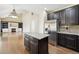 Kitchen area with island, stainless steel appliances and view to open living room with fireplace at 19061 E Powers Pl, Aurora, CO 80015