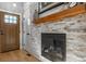 Modern fireplace with a stone accent wall and a wooden mantel at 5519 Fullerton Cir, Highlands Ranch, CO 80130