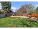 Spacious backyard featuring lush lawn, wooden fence, and cozy seating area with a fire pit at 12155 W 68Th Pl, Arvada, CO 80004