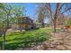 Expansive backyard featuring a lush lawn, mature trees, and an outdoor patio with pergola at 12155 W 68Th Pl, Arvada, CO 80004