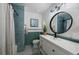 Bathroom featuring blue tile in the shower and a modern white vanity at 12155 W 68Th Pl, Arvada, CO 80004