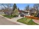 Aerial view of the property featuring a well-maintained lawn, mature trees, and a spacious driveway at 12155 W 68Th Pl, Arvada, CO 80004