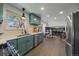 Charming kitchen with teal cabinets, stainless steel appliances, and eat in breakfast nook with views at 12155 W 68Th Pl, Arvada, CO 80004