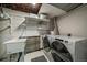 Functional laundry room with modern washer and dryer, utility sink, and ample storage shelves at 12155 W 68Th Pl, Arvada, CO 80004