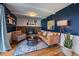 Cozy living room featuring a brick fireplace, hardwood floors, and tasteful decor at 12155 W 68Th Pl, Arvada, CO 80004